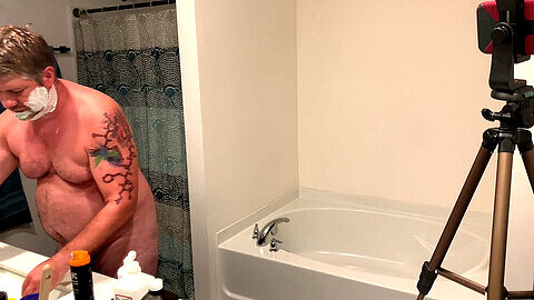 Tätowierter und gepiercter Kerl zeigt perverse Show unter der Dusche
