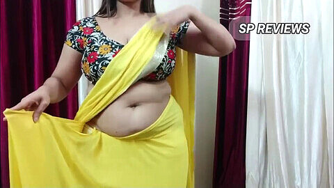 Femme mûre aux gros seins pose en sari jaune sexy.