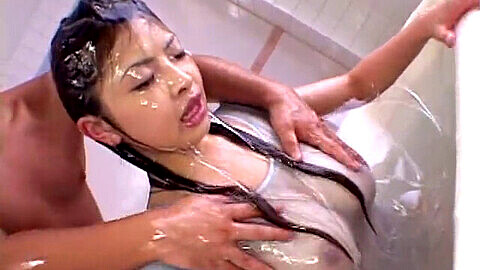 Chica japonesa de grandes pechos tomando un baño con loción