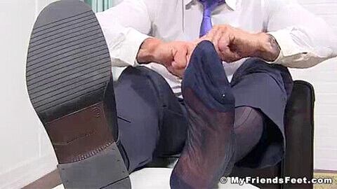 Uomo d'affari maturo e grinzoso mostra i suoi deliziosi piedi in solitaria all'ufficio