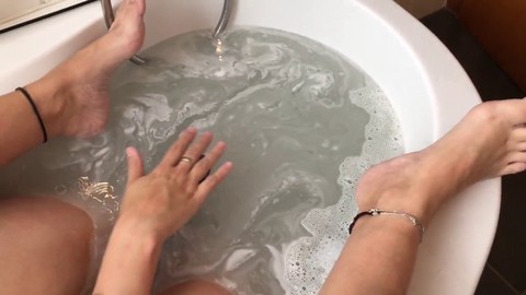 La ragazza arrapata si concede al feticismo del piede, alla pedicure e al gioco con il dildo nella vasca da bagno
