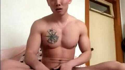 Oso asiático musculoso con tatuajes se complace a sí mismo en una sesión en solitario.