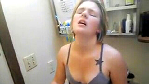 Teen lesbian with see-through clothes fingers her friend in the bathroom