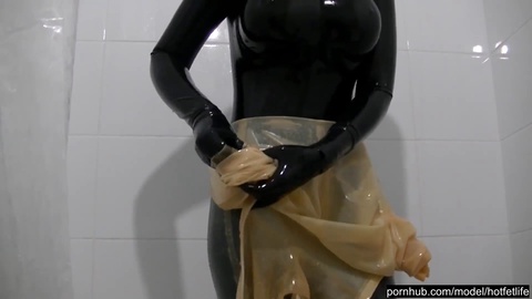Naughty babe indulges in wet shower play wearing double layered, black rubber spandex catsuits